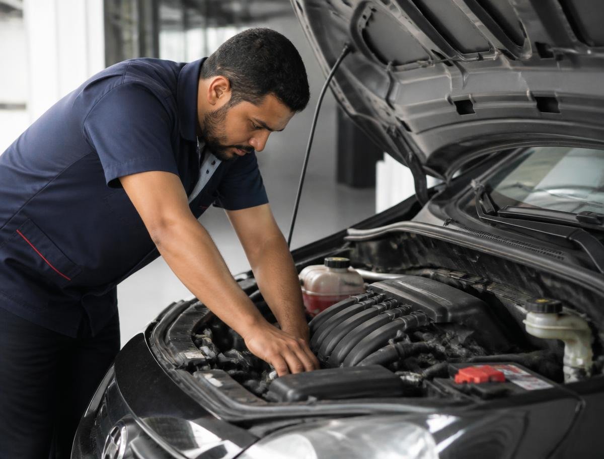 Mecânico inspecionando o motor de um carro na oficina em Pitanga